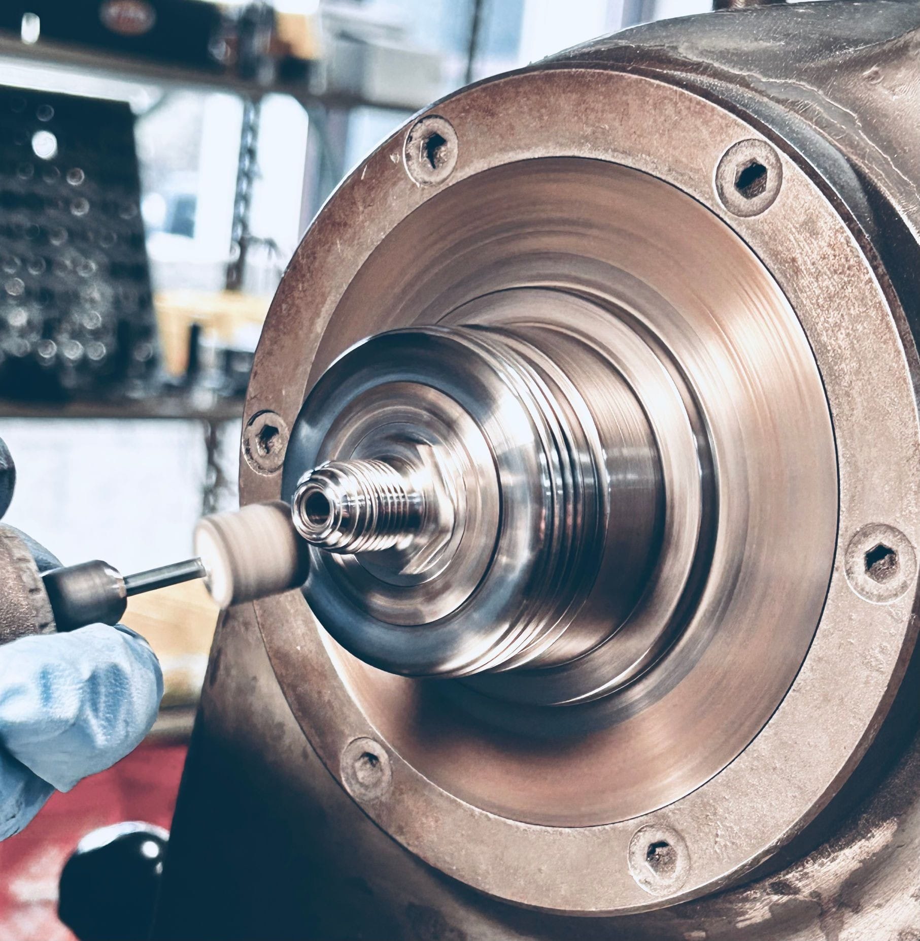 Operator hand polishing a part as a finishing operation on a Hardinge Chucker in the SPI workshop